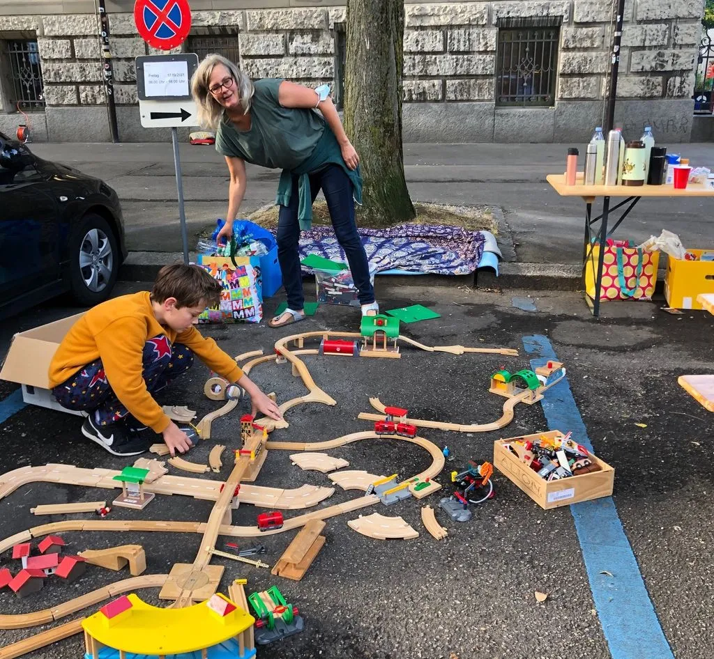 Kind mit Brio-Bahn auf Parkplatz