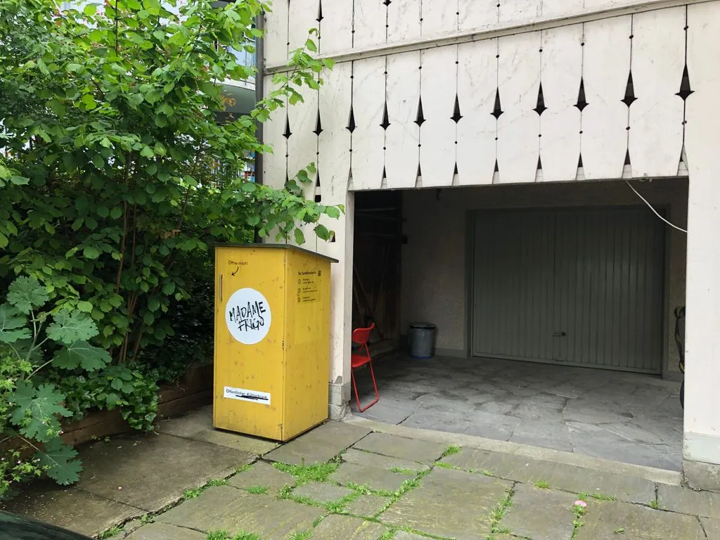 öffentlicher Kühlschrank vor Garagentor
