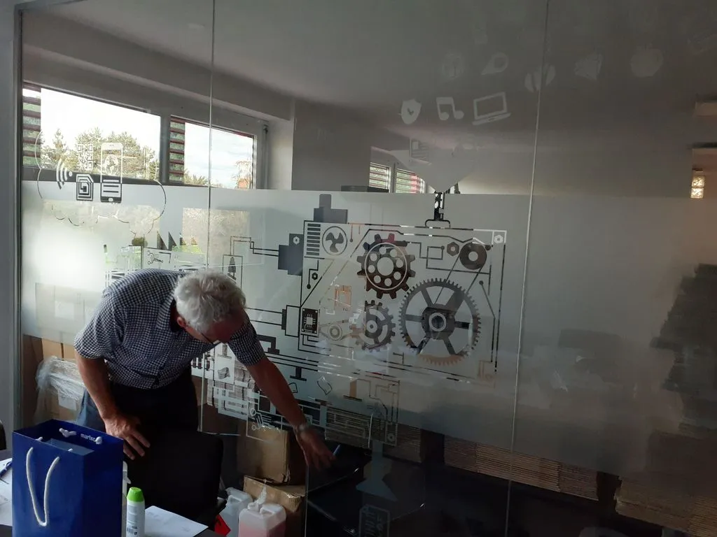 Storyteller vor einer Wand mit technischen Entwürfen