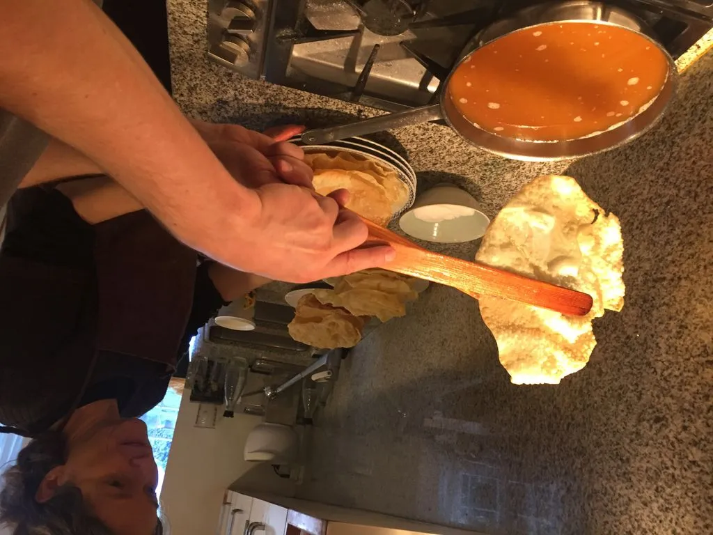 Fasnachtschüechli werden über die Pfanne gehalten.