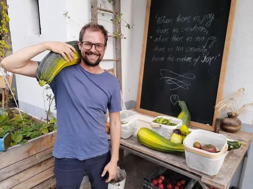 Lachende Person mit grosser Zucchetti auf Schulter.