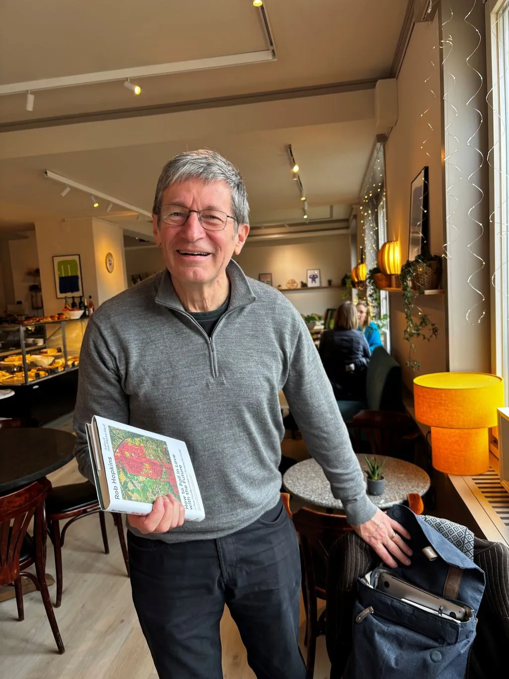 Storyteller in einem Café hält ein Buch in der Hand.